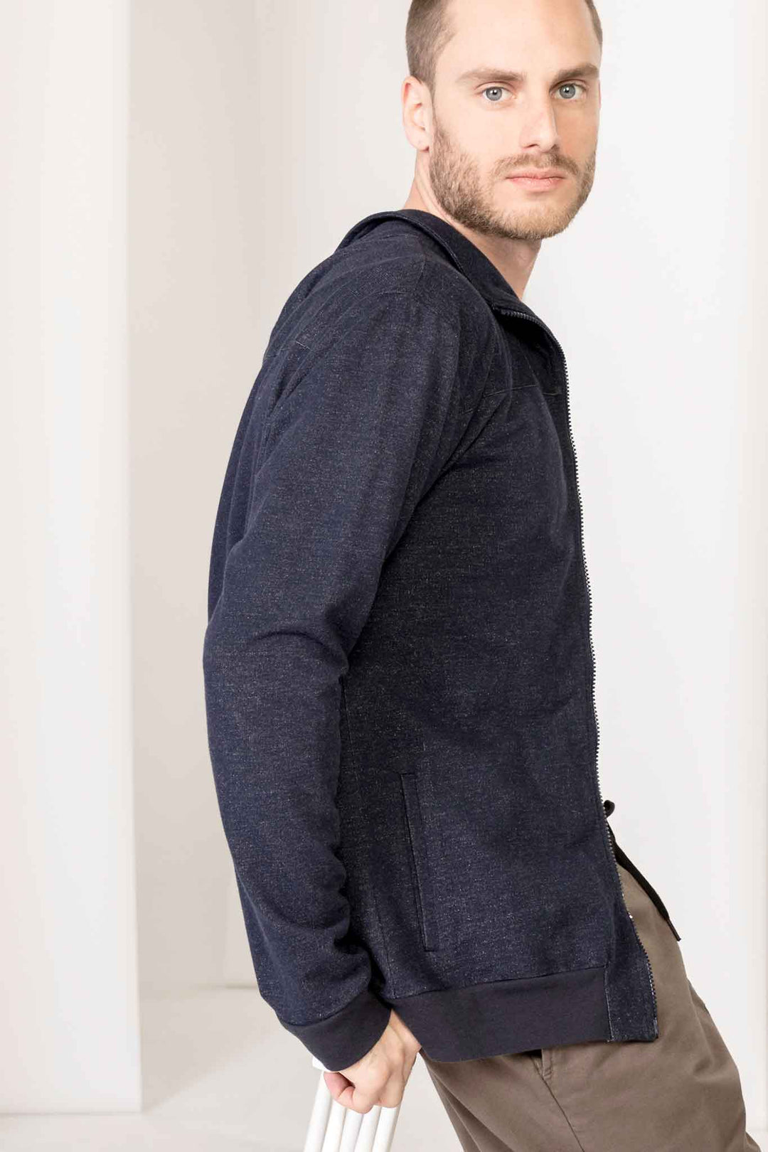 Seitliche Ansicht einer melierten, dunkelblauen Jerseyjacke für Herren. Unkomplizierter, legerer Look